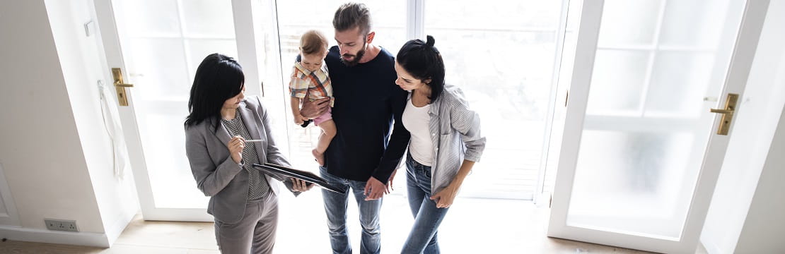 Family speaking with real estate agent in a home.